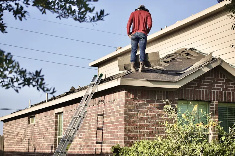 Professional roofer working on a residential roof in Des Peres